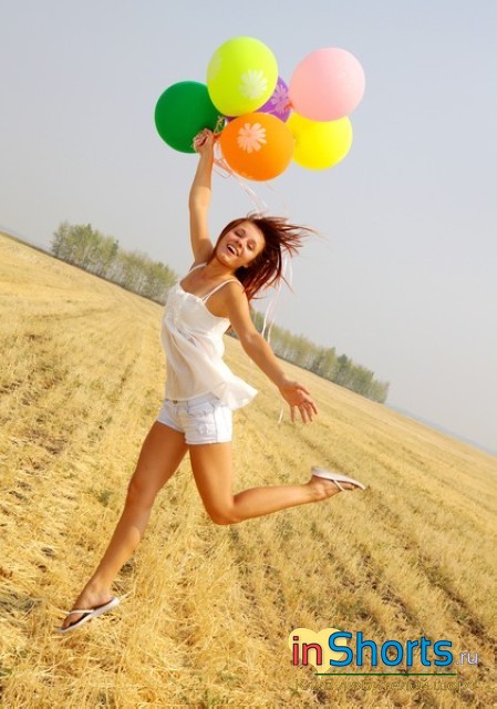 светлая девушка с шариками среди поля