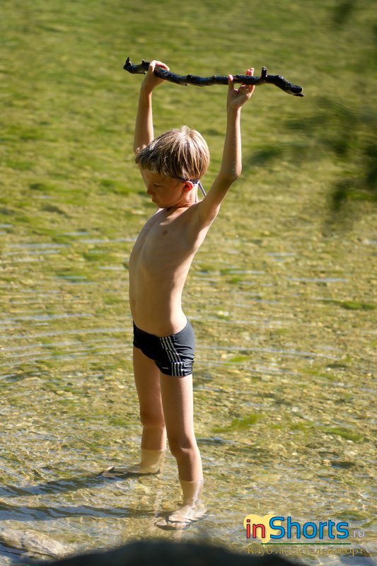 голый мальчик в воде с палкой