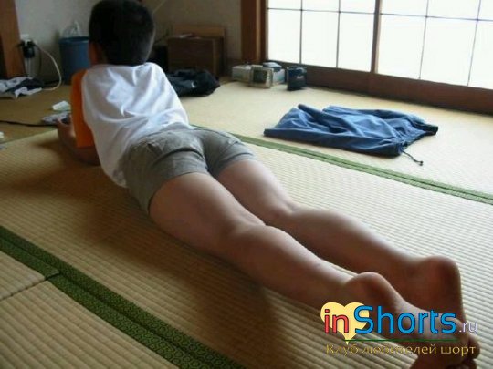 японский мальчик в шортах на животе