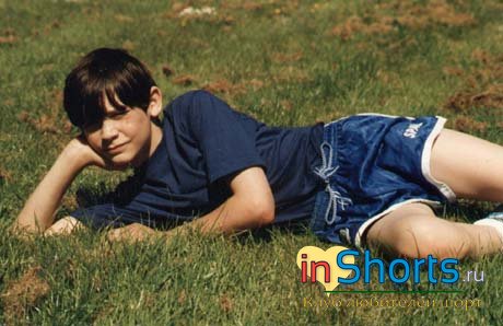 12-летний пацанчик в траве с короткими шортами