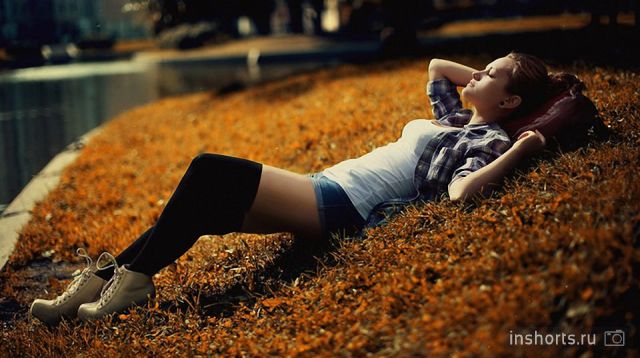 девушка в коротких шортах лежит на травке